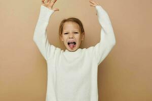 portret van gelukkig glimlachen kind meisje vreugde poseren emoties mode beige achtergrond foto