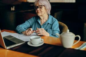 gelukkig senior vrouw werken in voorkant van laptop toezicht houden op zittend levensstijl ongewijzigd foto