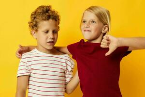 schattig peuter- kinderen knuffelen mode kinderjaren vermaak geel achtergrond foto