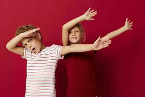 schattig peuter- kinderen emoties staan kant door kant in elke dag kleren rood achtergrond foto