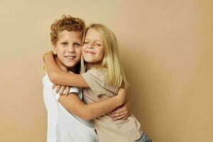 jongen en meisje in t-shirts knuffels beige achtergrond vriendschap foto