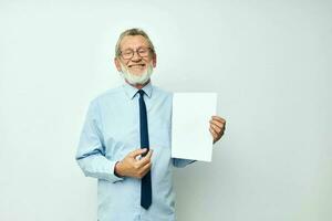 portret van gelukkig senior Mens Holding documenten met een vel van papier licht achtergrond foto