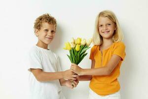 schattig elegant kinderen met een boeket van bloemen geschenk verjaardag vakantie kinderjaren licht achtergrond foto