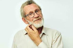 foto van gepensioneerd oud Mens met een grijs baard in een overhemd en bril licht achtergrond