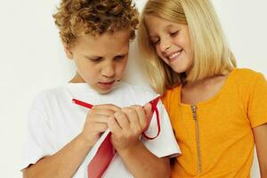 portret van schattig kinderen pret in kleurrijk t-shirts met een kladblok geïsoleerd achtergrond ongewijzigd foto