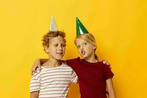 portret van schattig kinderen in gewoontjes kleren met petten Aan de hoofd Aan gekleurde achtergrond foto