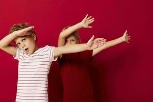 jongen en meisje glimlachen en poseren in gewoontjes kleren tegen Aan gekleurde achtergrond foto