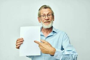 ouderen Mens Holding een vel van papier kopie-ruimte poseren geïsoleerd achtergrond foto