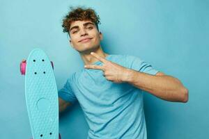 kinky vent skateboard in hand- in blauw t-shirts geïsoleerd achtergrond foto