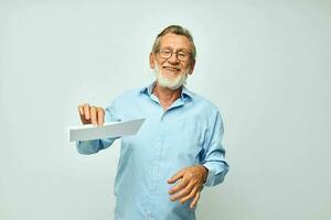 senior grijs haar Mens Holding een vel van papier kopie-ruimte poseren geïsoleerd achtergrond foto