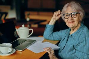 gelukkig senior vrouw werken in voorkant van laptop toezicht houden op zittend gepensioneerd vrouw chatten ongewijzigd foto