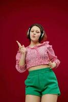 mooi meisje in groen shorts beweegt in hoofdtelefoons luisteren naar muziek- foto