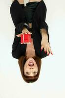 aantrekkelijk vrouw poseren met rood geschenk doos verrassing licht achtergrond foto