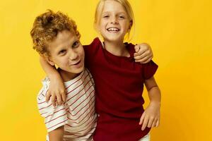 schattig peuter- kinderen knuffelen mode kinderjaren vermaak Aan gekleurde achtergrond foto