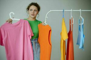 mooi meisje groen t-shirts in de buurt kleren hangers geïsoleerd achtergronden ongewijzigd foto