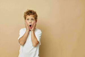 gekruld jongen kinderen stijl mode emoties beige achtergrond foto