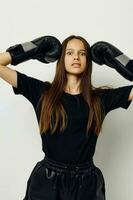 mooi meisje in boksen handschoenen stempel in zwart broek en een t-shirt geschiktheid opleiding foto