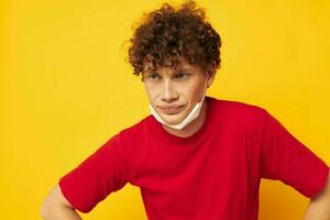 schattig roodharig vent in een rood t-shirt medisch masker bescherming geïsoleerd achtergrond ongewijzigd foto