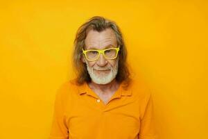 foto van gepensioneerd oud Mens geel t-shirt en bril poseren geel achtergrond