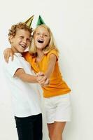 afbeelding van positief jongen en meisje in veelkleurig petten verjaardag vakantie emotie licht achtergrond foto