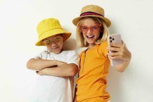 jongen en meisje vervelend hoeden met telefoon mode poseren kinderjaren foto