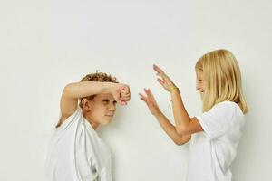 schattig elegant kinderen in wit t-shirts zijn staand De volgende naar levensstijl ongewijzigd foto