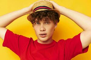 portret van een jong gekruld Mens in een rood t-shirt met een mode hoed levensstijl ongewijzigd foto