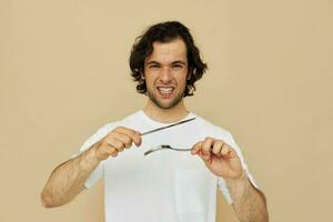 aantrekkelijk Mens in een wit t-shirt met mes met vork levensstijl ongewijzigd foto