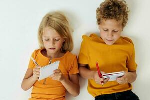 afbeelding van positief jongen en meisje tekening pret spellen met kladblok kinderjaren levensstijl ongewijzigd foto