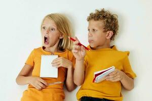 jongen en meisje liggen Aan de verdieping met blocnotes en potloden kinderjaren levensstijl ongewijzigd foto