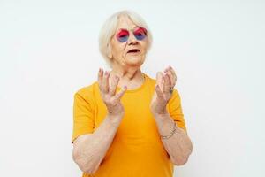 foto van gepensioneerd oud dame in een geel t-shirt poseren licht achtergrond