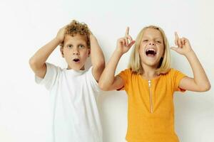 twee blij kinderen gewoontjes kleren poseren emoties studio geïsoleerd achtergrond ongewijzigd foto