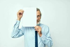 ouderen Mens Holding documenten met een vel van papier licht achtergrond foto