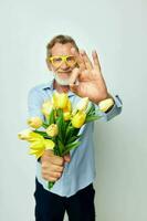 portret van gelukkig senior Mens een boeket van bloemen met bril net zo een geschenk ongewijzigd foto
