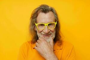 foto van gepensioneerd oud Mens geel t-shirt en bril poseren geel achtergrond