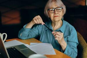 mooi volwassen senior vrouw documenten werk vel van papier en pen sociaal netwerken ongewijzigd foto