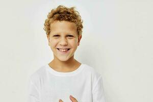 gekruld jongen in een wit t-shirt poseren pret kinderjaren ongewijzigd foto