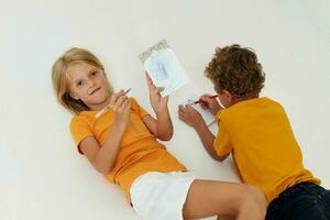 schattig peuter- kinderen emoties tekening samen kladblok en potloden licht achtergrond ongewijzigd foto