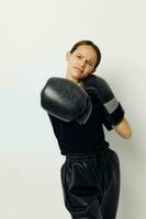 jong mooi vrouw in zwart sport- uniform boksen handschoenen poseren geïsoleerd achtergrond foto