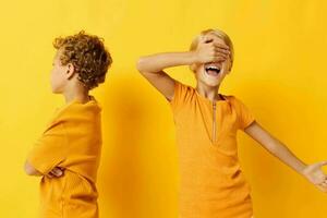 portret van schattig kinderen in geel t-shirts staand kant door kant kinderjaren emoties geel achtergrond ongewijzigd foto