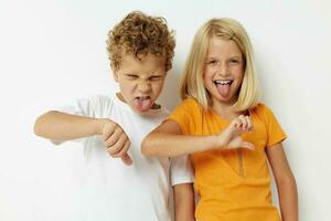 twee blij kinderen gewoontjes kleren poseren emoties studio geïsoleerd achtergrond ongewijzigd foto