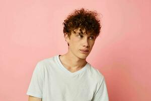 vent met rood gekruld haar- zomer kleren wit t-shirt poseren geïsoleerd achtergrond ongewijzigd foto