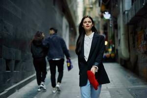 mode vrouw toerist in elegant kleren in een jasje en rood baret wandelen naar beneden een versmallen stad straat vliegend haar- en gelukkig reis, Frans stijl, filmische kleur, retro stijl. foto