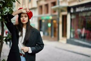 vrouw model- staat Aan de straat in de stad in een jasje en rood baret, filmische Frans mode stijl kleding, reizen naar Istanbul foto