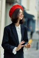 mode vrouw glimlach voorjaar wandelen in de stad in elegant kleren met rood lippen en rood baret, reis, filmische kleur, retro wijnoogst stijl, stedelijk mode levensstijl. foto