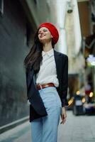 mode vrouw glimlach met tanden portret wandelen toerist in elegant kleren in jasje met rood lippen wandelen naar beneden versmallen stad straat vliegend haar, reis, filmische kleur, retro wijnoogst stijl. foto