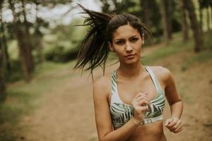 jonge fitness vrouw draait op bospad foto