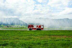 brand vechten met water spuiten. brand vrachtauto en brand motor met brand Heren. noodgeval en vuurzee. brand ramp en crisis. foto