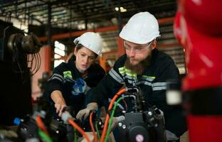 beide van ingenieurs installeren een klein robot arm is wezen geïnstalleerd voor testen. voordat Bezig met verzenden naar klanten voor industrieel gebruiken. foto