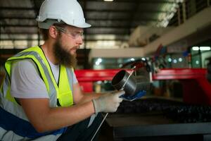 een mechanisch ingenieur meten Product dimensies van nieuw machinerie geïnstalleerd foto